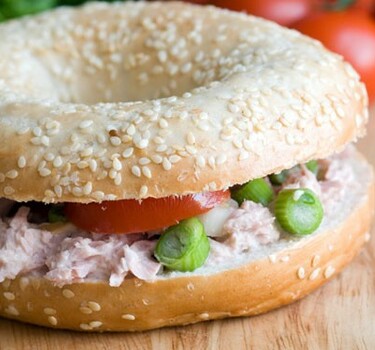 Bagel met zelfgemaakte tonijnsalade, cornichons en rode ui