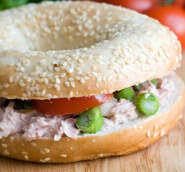 Bagel met zelfgemaakte tonijnsalade, cornichons en rode ui