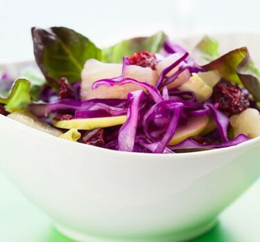 Rodekool-appelsalade met amandelen, rozijnen en granaatappeldressing