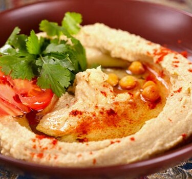 Hummus met tomaten en basilicum