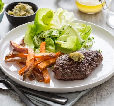 Steak frites met simpele beurre Café de Paris, zoete-aardappelfrietjes en tuinkruidensalade