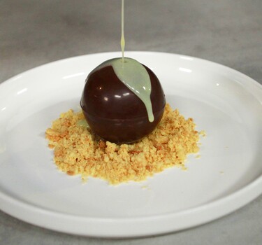 Chocoladebal met amandelbavarois en warme witte chocoladesaus