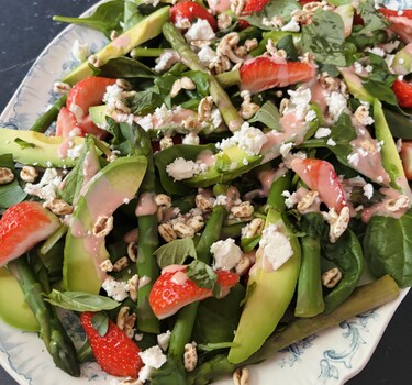 spinaziesalade met aardbeidressing op een bord