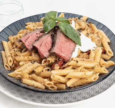 bord met pasta en rood vlees van de bbq