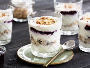 Feestelijke ontbijttrifle met laagjes jam, knapperige noten, voedzame muesli en yoghurt (of kwark)