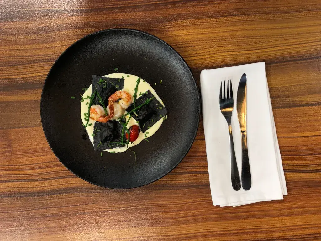 Ravioli met inktvisinkt, zeebaars, coquilles en gorgonzolasaus