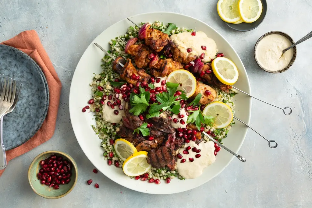 Mixed grill van kip met hummus en parelcouscoussalade