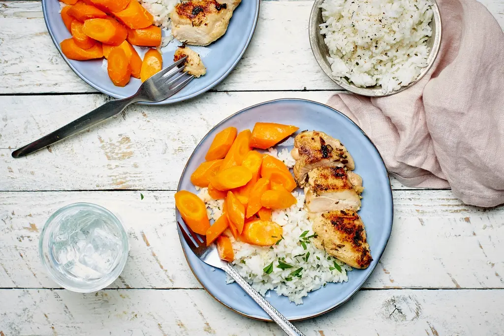 Gegrilde kippendijen met sinaasappelwortelen en rijst